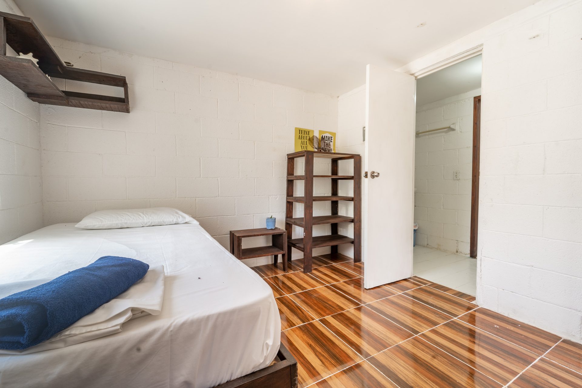 Rooms Wind — single bed, wood-stripe floor, white brick walls